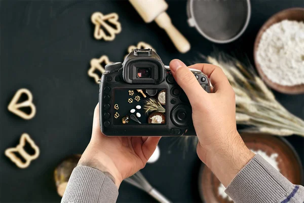 Appareil photo numérique reflex mono-objectif dans les mains. Homme photographe fait des photos. Les mains masculines tiennent la caméra en gros plan — Photo