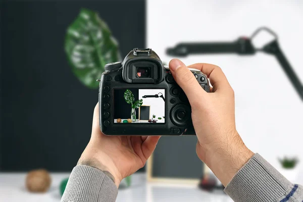 Цифрова однооб'єктивна рефлекторна камера в руках. Людина-фотограф робить фотографії. Чоловічі руки тримають камеру крупним планом — стокове фото