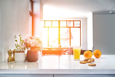 İştah açıcı tatlı portakal suyu ve bir mutfak beyaz bir masada bir kahvaltı için ayakta gözlük içme.