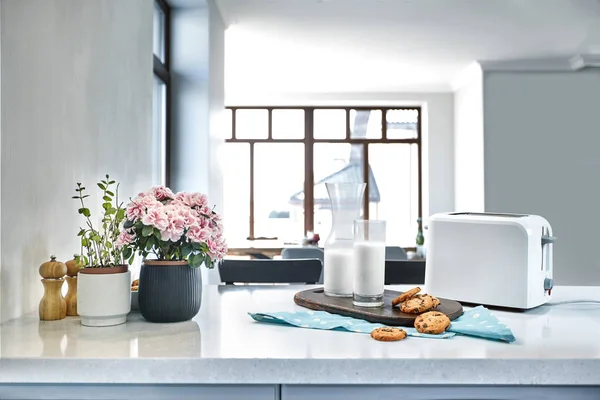 Kekse und Milch mit einer Glasmilchflasche auf dem Küchentisch für einen After-School-Snack mit Keksen und Milch — Stockfoto