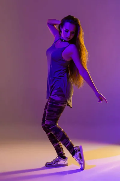 Танцівниця сучасного стилю позує на фоні студії. Фільтри кольорів — стокове фото