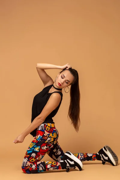 Νεαρή γυναίκα χορεύτρια στο ιστορικό στούντιο. Νέοι μοντέρνο στυλ κορίτσι χορεύτρια κάθεται στο πάτωμα στο studio. — Φωτογραφία Αρχείου