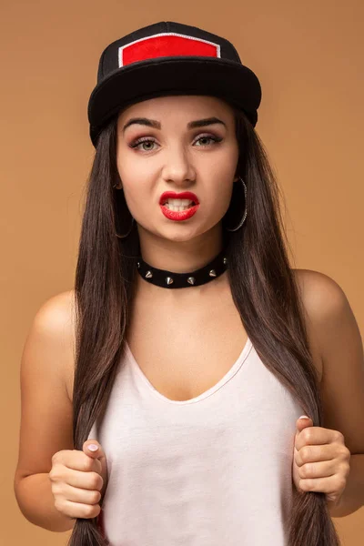 Close up ritratto positivo di bella ragazza con incredibili capelli lunghi bruna, cappello sportivo luminoso, trucco luminoso, faccia divertente pazzo . — Foto Stock