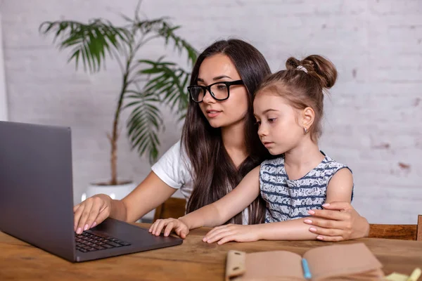 Молодая мать с маленькой дочерью делают покупки в Интернете за персональным компьютером — стоковое фото