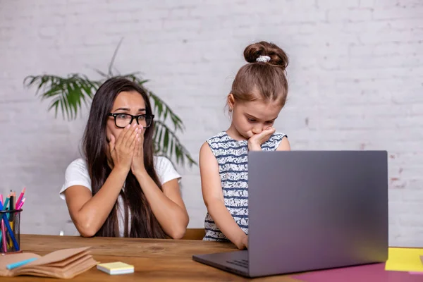 Раздраженная мать смотрит на ошибки ее дочери домашнее задание — стоковое фото