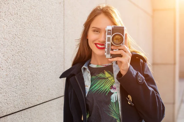 街路市のレトロなカメラで写真を作る幸せな内気な少女。太陽フレア — ストック写真