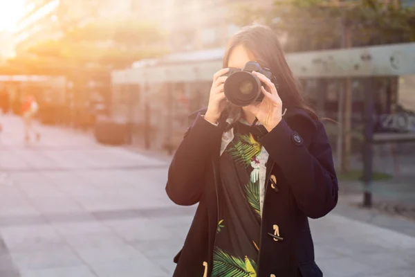 Porträt einer professionellen Fotografin auf der Straße, die mit einer Kamera fotografiert. — Stockfoto