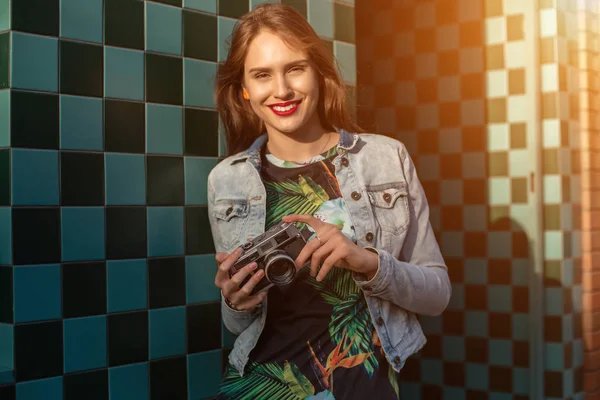 Жизнерадостный модный портрет молодой стильной женщины, идущей по улице, с фотоаппаратом, улыбающейся, наслаждающейся сорняками . — стоковое фото