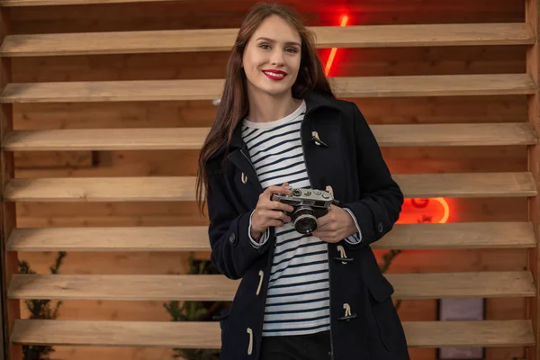 Feliz joven hipster mujer sostiene retro foto cámara —  Fotos de Stock