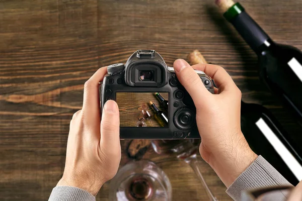 Digital single-lens reflex camera in hands. Man photographer makes photos. Male hands hold the camera close-up