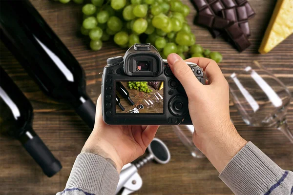 Digital single-lens reflex camera in hands. Man photographer makes photos. Male hands hold the camera close-up