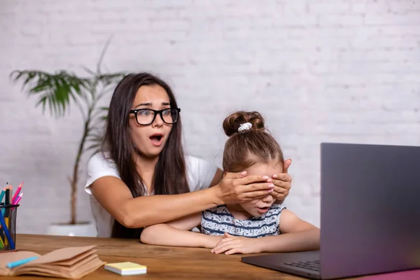 Una madre joven con una hija pequeña están de compras en Internet en el ordenador personal —  Fotos de Stock