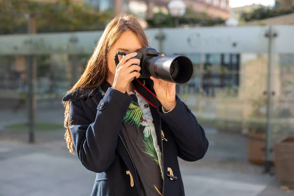 Porträt einer professionellen Fotografin auf der Straße, die mit einer Kamera fotografiert. — Stockfoto