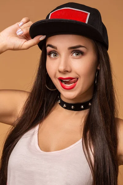 Hip-hop chica en gorra con el pelo largo y oscuro. Retrato de moda de una joven moderna con gorra —  Fotos de Stock