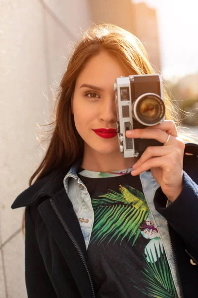 Boldog csípő lány így fénykép retro fényképezőgép a város utcai. Napsütés fáklyát — Stock Fotó