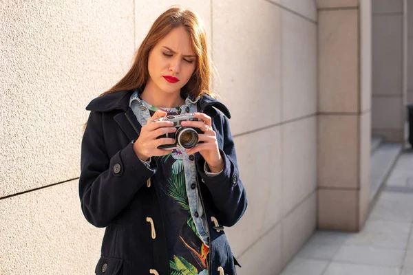 Menina hipster feliz fazendo foto com câmera retro na rua da cidade — Fotografia de Stock