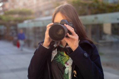 Portre profesyonel kadın fotoğrafçı sokakta bir kamera fotoğraf çekimi.