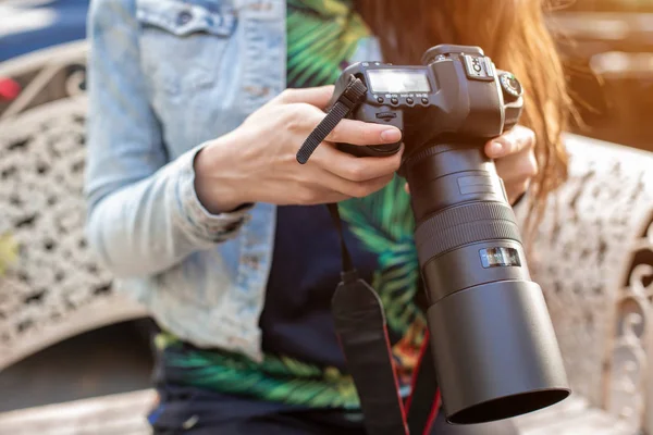 Nahaufnahme weiblicher Hände, die eine professionelle Kamera halten. Fotografin mit professioneller Kamera. — Stockfoto