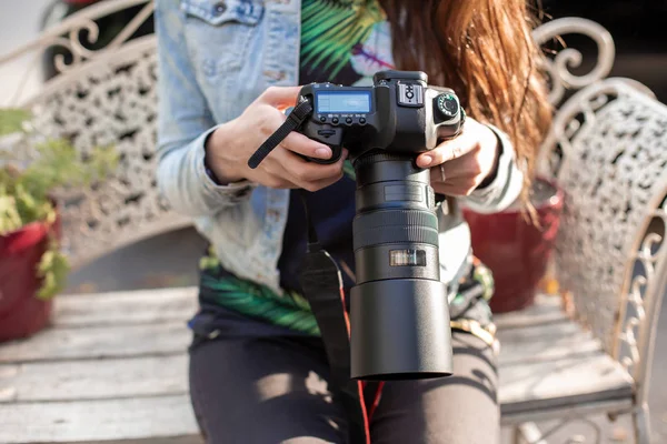 Close-up de mãos femininas segurando uma câmera profissional. Fotógrafa feminina com uma câmera profissional . — Fotografia de Stock