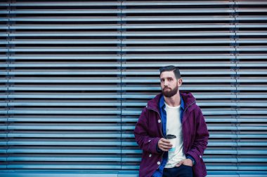 Kahve içme mor kış ceket yakışıklı genç adam. Adam sokakta kahve içme.