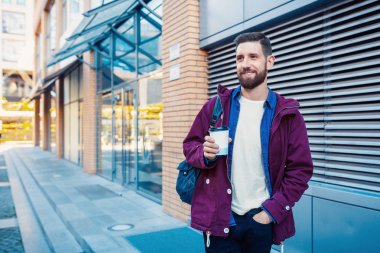 Kahve içme mor kış ceket yakışıklı genç adam. Adam sokakta kahve içme.