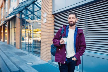 Kahve içme mor kış ceket yakışıklı genç adam. Adam sokakta kahve içme.