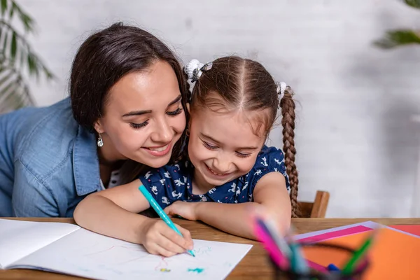 Счастливая семья мать и дочь вместе рисуют маркерами . — стоковое фото