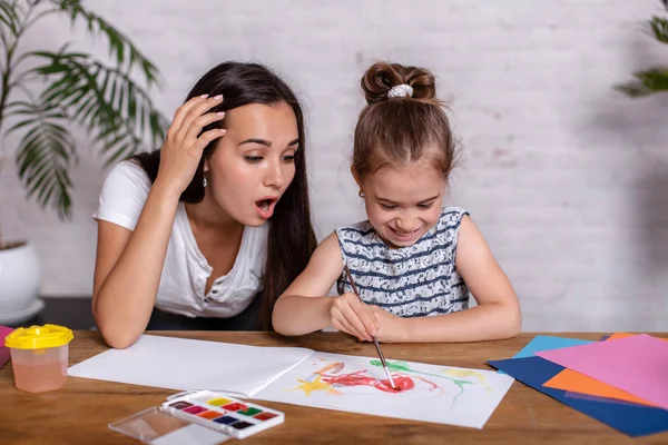 Счастливая семья. Мать и дочь вместе рисуют . — стоковое фото