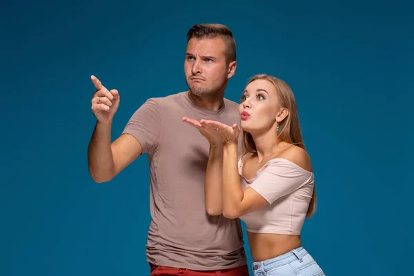 Retrato de homem bonito e bela mulher ou jovem casal olhando para longe com cara engraçada e beijando com amor . — Fotografia de Stock