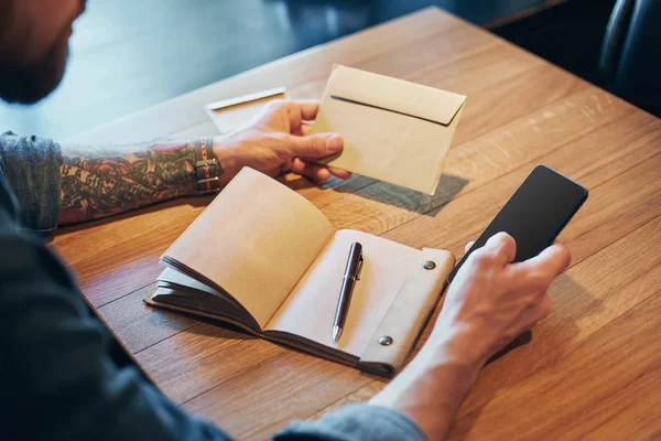 Mano de hombre con la escritura de la pluma en el cuaderno en una mesa de madera. Primer plano — Foto de Stock