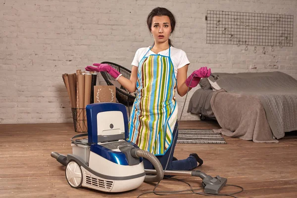 Giovane donna che apre aspirapolvere, possibile fallimento. Lavoro domestico in casa . — Foto Stock