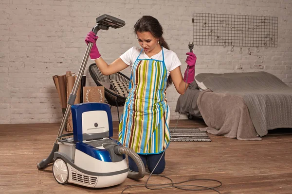年轻女子打开吸尘器, 可能失败。在家中工作. — 图库照片