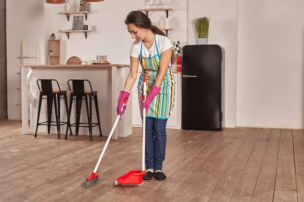 Mujer joven barriendo piso en la cocina — Foto de Stock