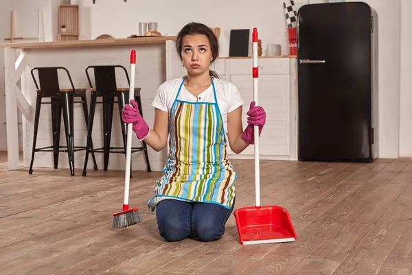 Giovane donna spazzare pavimento sulla cucina — Foto Stock