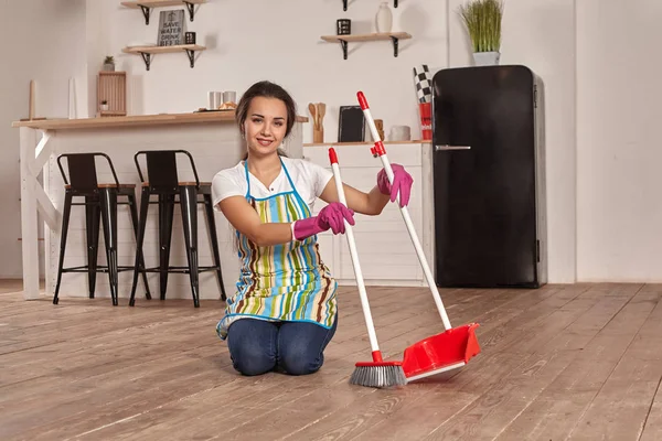 Молода жінка піднімає підлогу на кухні — стокове фото