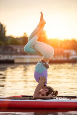 Yoga pozisyonu almış sporcu bir kadın, yemek masasında yoga yapıyor, esneklik ve kas esnekliği için egzersiz yapıyor.
