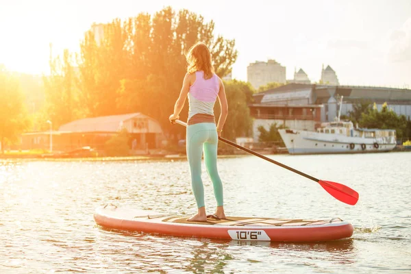 Женщина плавает на внедорожнике в солнечное утро. Посадка на весло - удивительный активный отдых во время отпуска . — стоковое фото