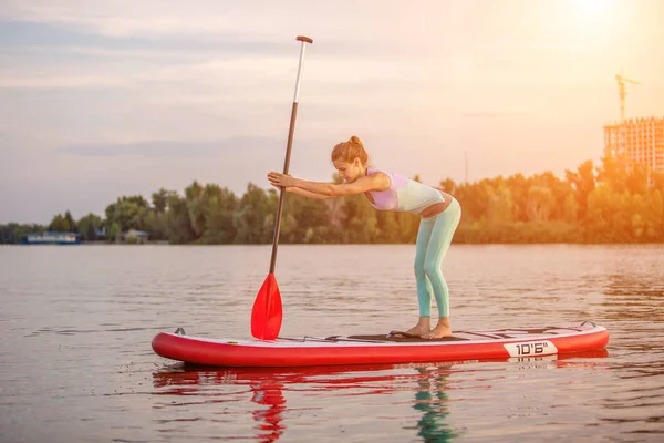 Sportliche Frau in Yogaposition auf dem Paddleboard, Yoga auf dem Sup Board, Bewegung für Beweglichkeit und Dehnung der Muskeln — Stockfoto