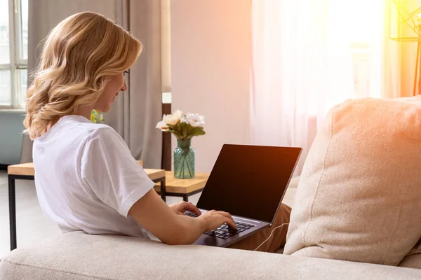 Nő a kanapé makett üres képernyő a laptop dolgozik. Üres másolat monitor hirdetés hely. Fekete képernyő. — Stock Fotó