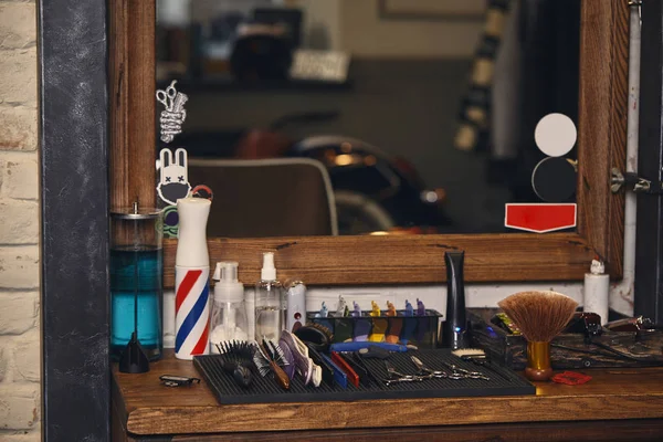 Nahaufnahme einer Reihe professioneller Friseurwerkzeuge auf einem Holzregal im Friseursalon — Stockfoto