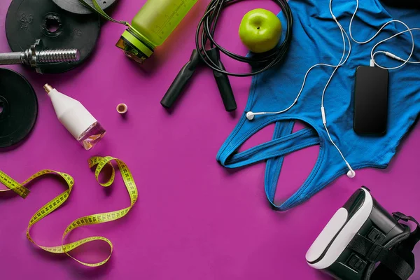 Gesundheit Fitness Hintergrund. Turnschuhe, Hantel, Stromgriff, grüner Apfel, Wasserflasche, blaues Hemd, Telefon und Kopfhörer auf dunklem Hintergrund. — Stockfoto