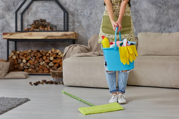 A takarítási szolgáltatást. Vödör, szivacs, vegyi anyagok palackok és felmosó kibír. Levágott kép egy nő, egy tincs a nappaliba — Stock Fotó