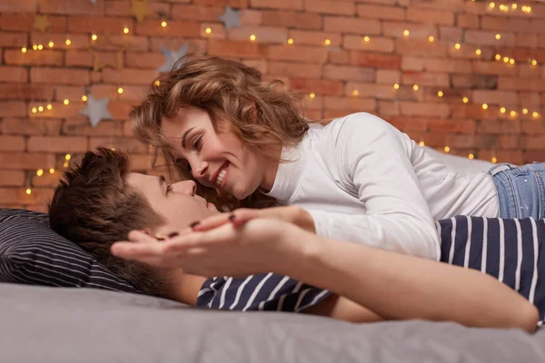 Caucásico joven hermosa pareja se acuestan en la cama y abrazándose mutuamente — Foto de Stock