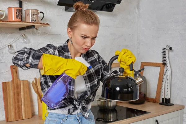 Domestic service and housekeeping concept, happy blonde lady cleaning kitchen kettle.