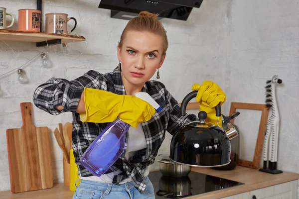 Domestic service and housekeeping concept, happy blonde lady cleaning kitchen kettle.