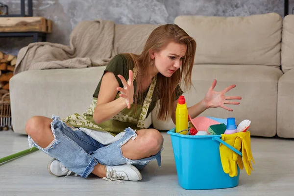 Женщина домохозяйка чувствует усталость, сидя на полу в гостиной после уборки дома . — стоковое фото