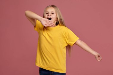 Sarı tişört, küçük kız. uzanıyor ve yawns
