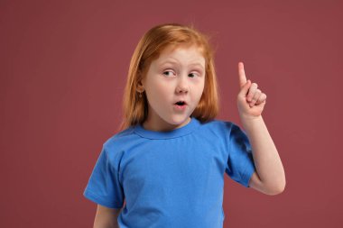 Portre sevimli redhead kırmızı zemin üzerine duygusal küçük kız