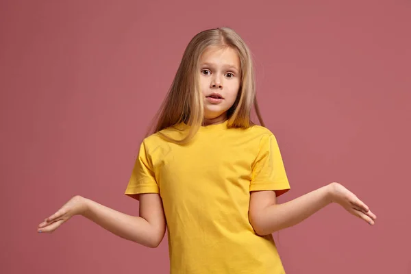 Uma menina de t-shirt amarela. não sabe a resposta — Fotografia de Stock