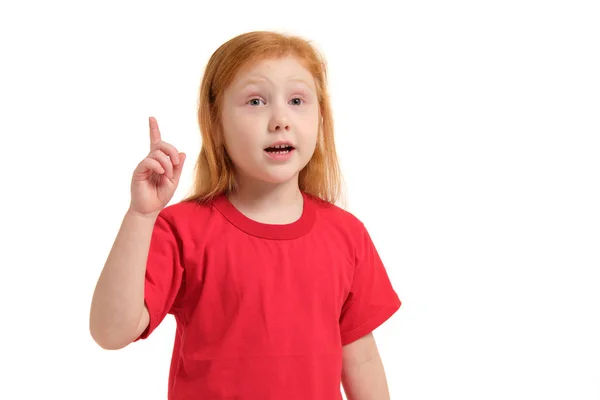 Портрет милої рудої емоційної дівчинки з пальцем вгору ізольовано на білому — стокове фото